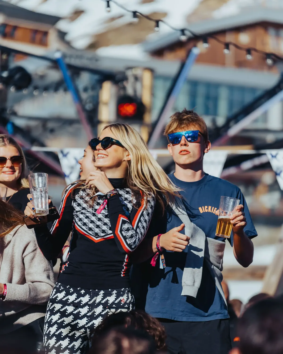 Members in ski jackets with drinks at an outdoor apres party