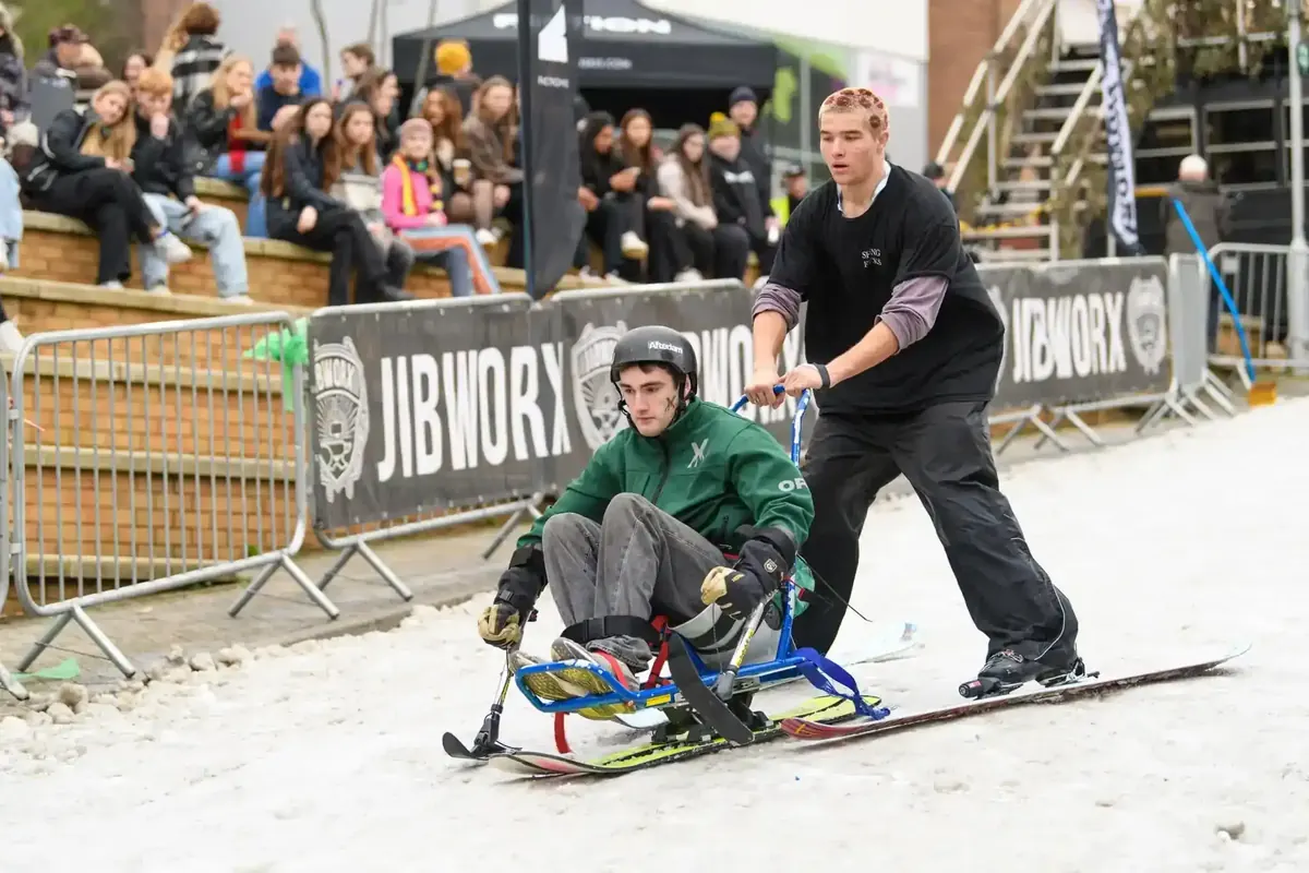Sit-skier guided down the Chill Hill slope by an instructor as part of the adaptive programme