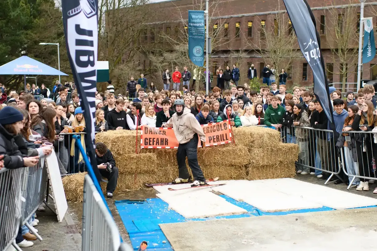 Skier landing beside the straw bales at Chill Hill with the crowd watching