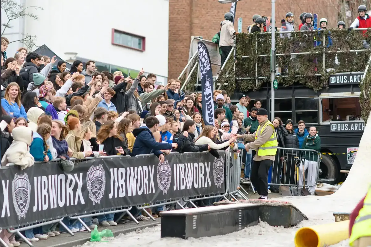 Wide view of the Chill Hill snow ramp with hundreds of spectators along the barriers