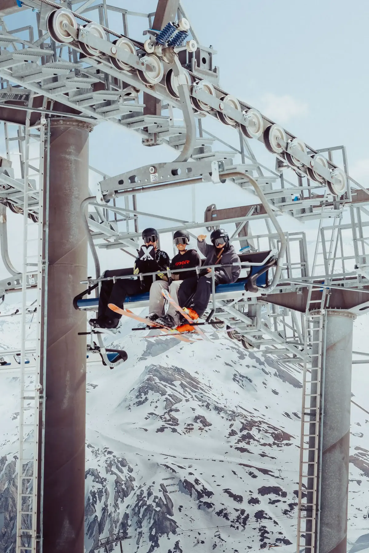 Members riding a chairlift over the piste