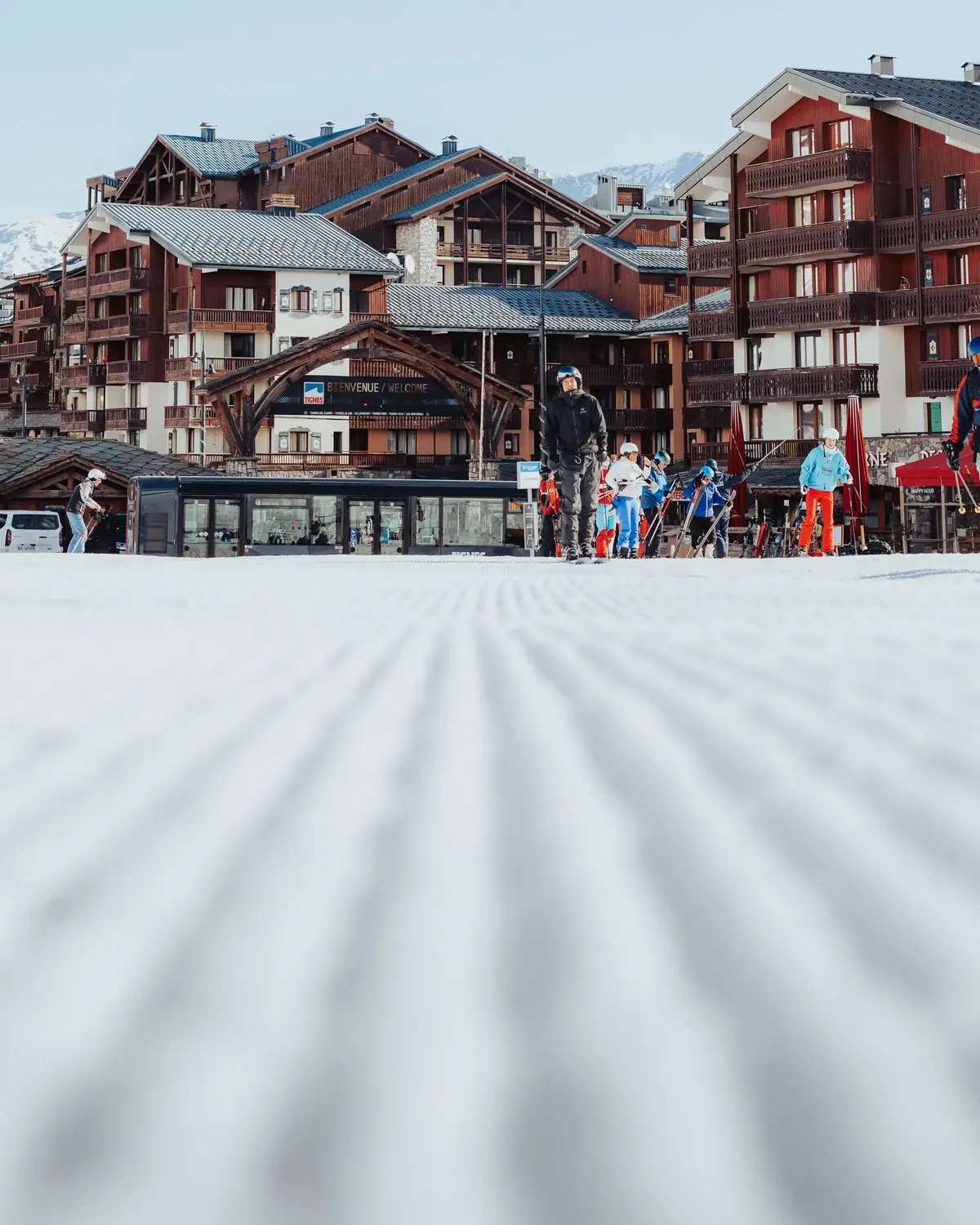Freshly groomed corduroy leading down to a resort village