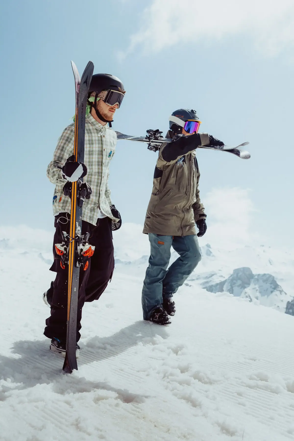 Two members walking across the snow carrying their skis