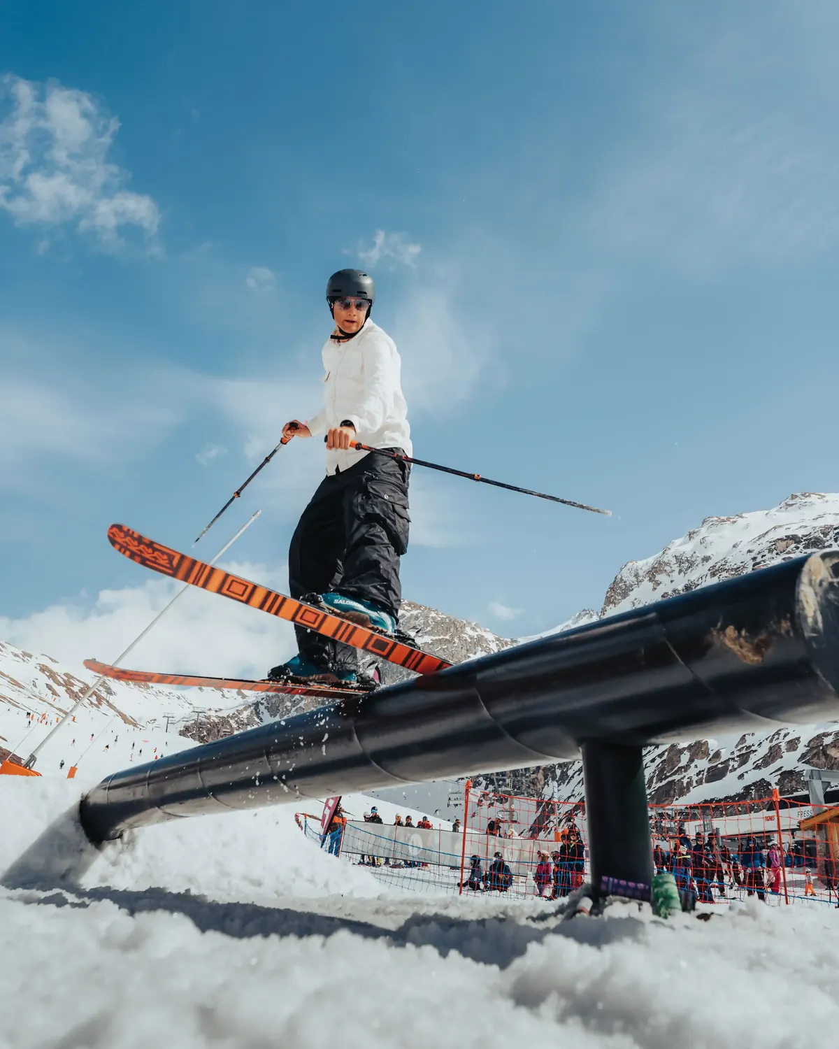 Skier sliding a long rail in the resort snowpark